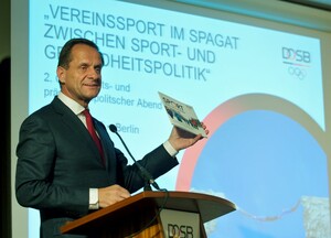 Alfons Hörmann präsentiert seinen Zuhörern die DOSB-Broschüre "Sport und Gesundheit".